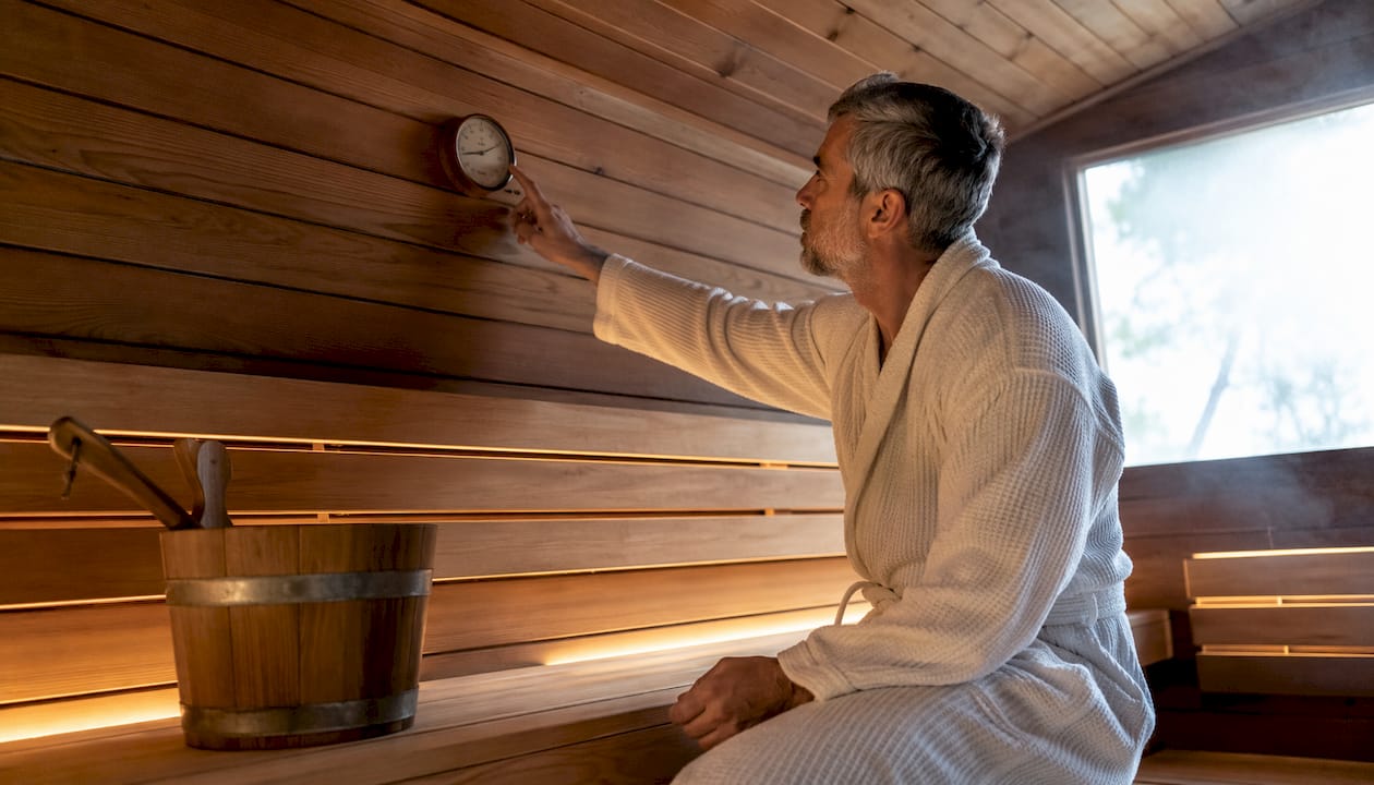 Man checking temperature in traditional sauna