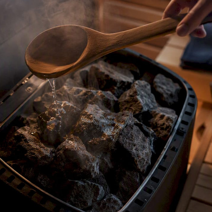 Pouring water on sauna heater stones