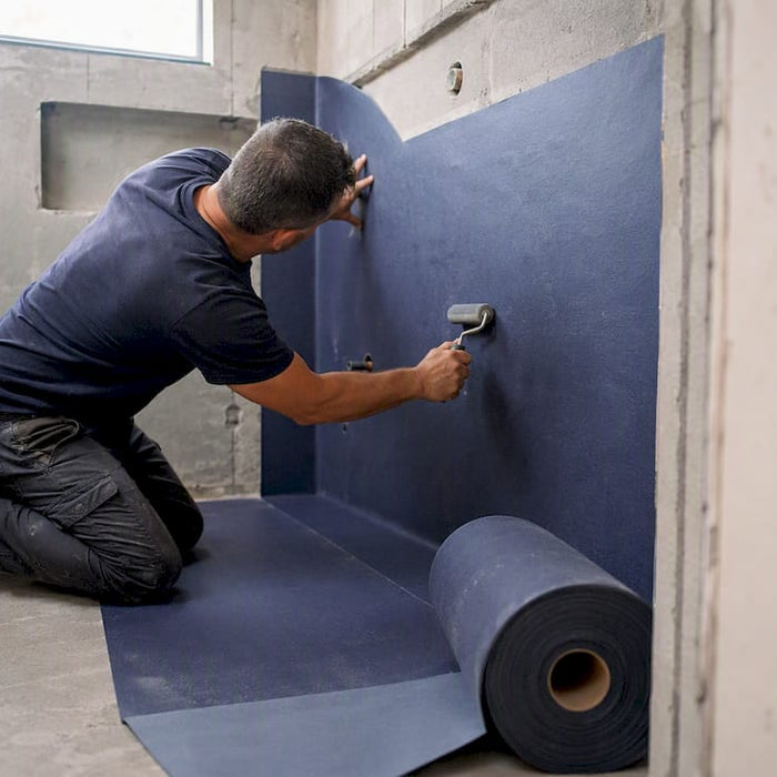 Contractor applying waterproof membrane in steam room