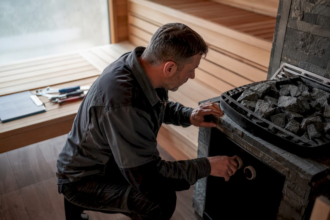 Facility manager photographing sauna heater rocks and control panel