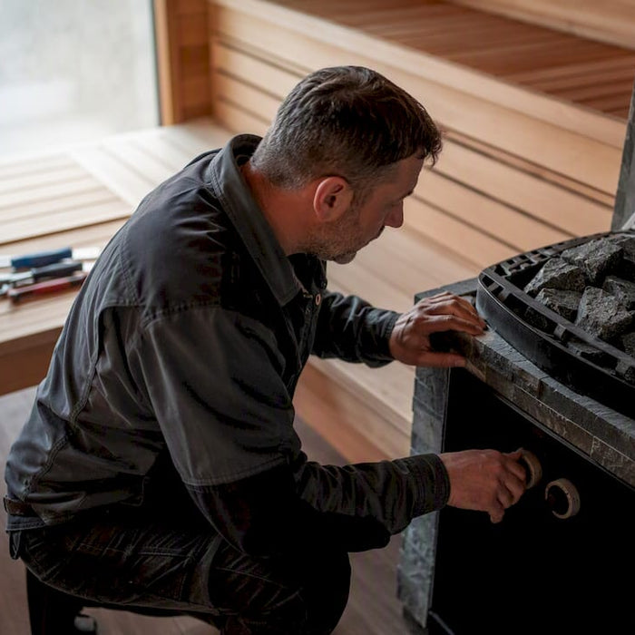 Facility manager photographing sauna heater rocks and control panel