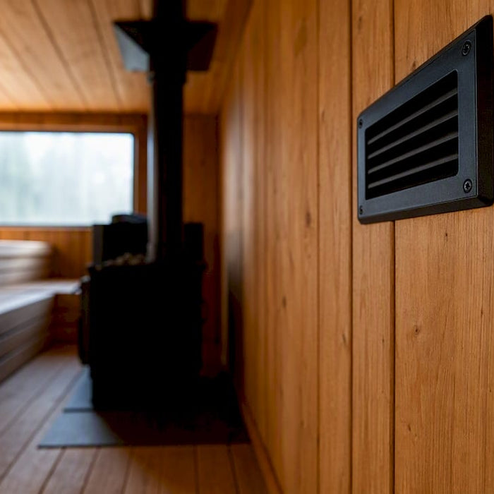 Wood-fired sauna fresh air inlet vent above stove