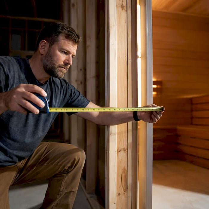 Builder measuring a sauna door rough opening