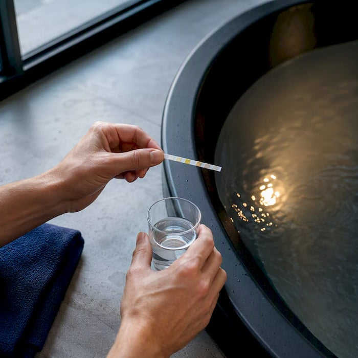 Hands testing cold plunge water