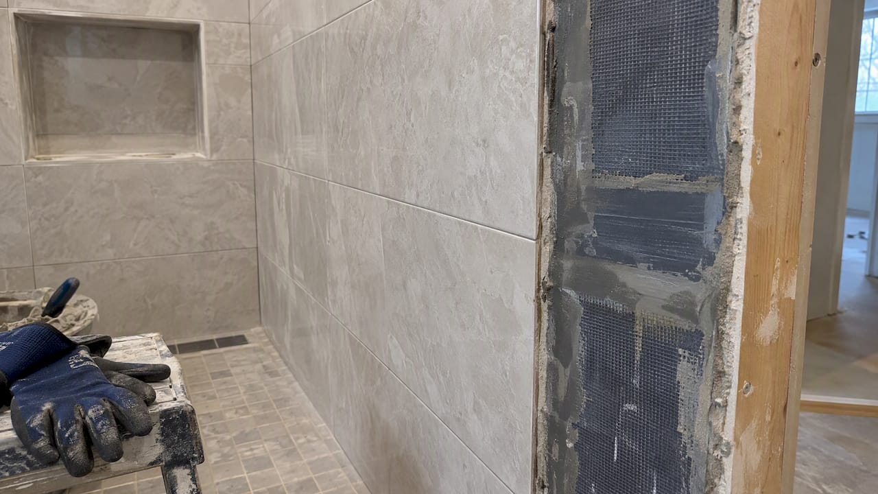 Steam shower tile beside exposed vapor membrane